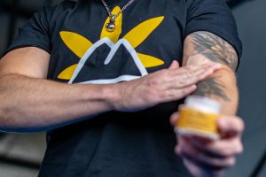 A man putting a cream on his arm tattoo.