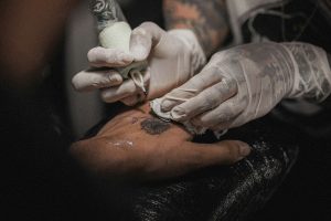 Tattoo artist making a tattoo on clients arm