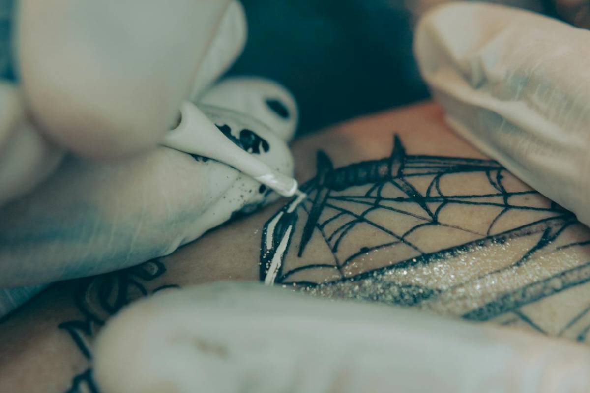 Artist filling in tattoo with white ink