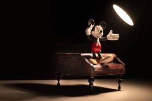 Mickey mouse toy on a piano with a lamp