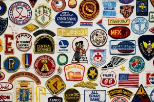 Different kinds and sizes of patches on a white wooden board