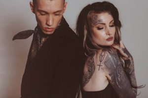 A man and a woman with tattoo symbols on their arms and back