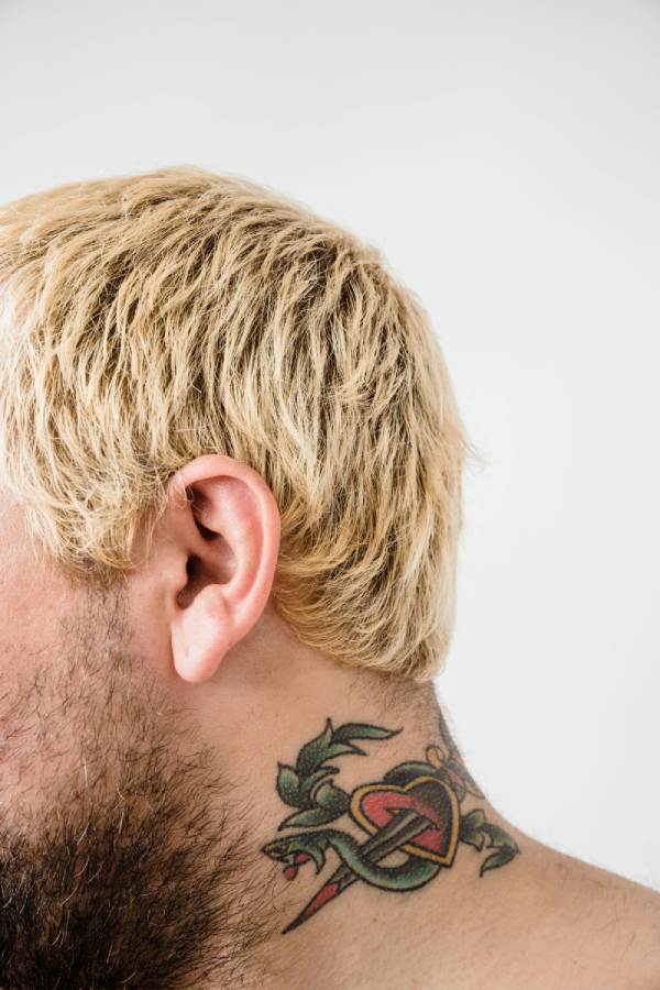 Blonde man with a heart stabbed with sword tattoo on his neck