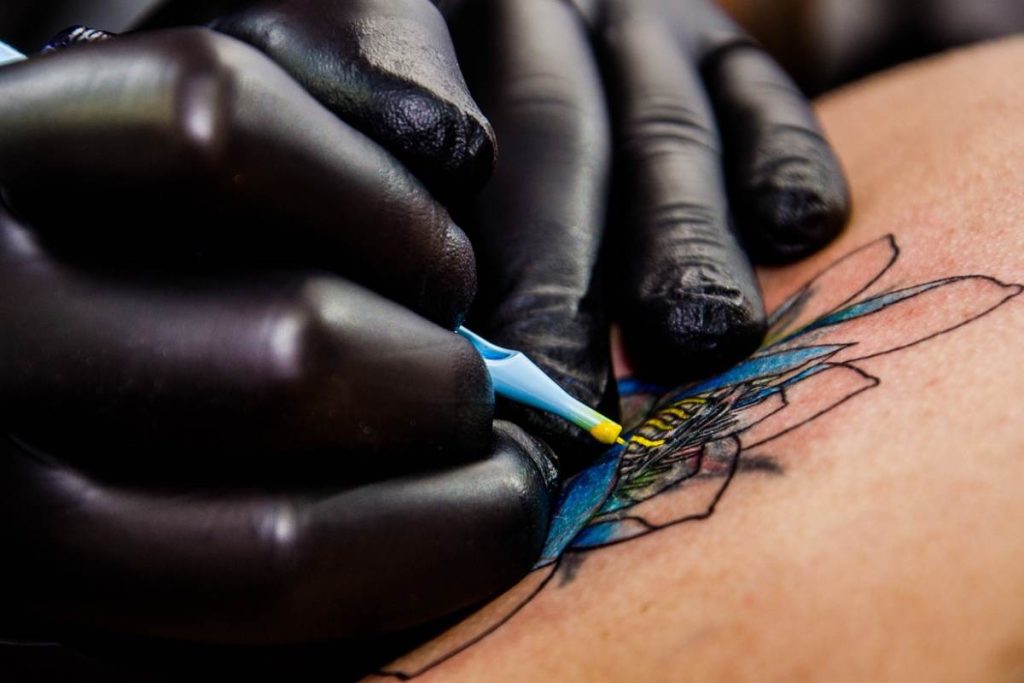 Tattoo artists hands making a lotus tattoo