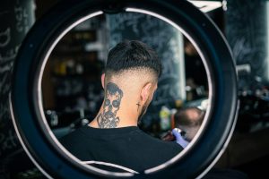 A man with a back joker neck tattoo in a studio