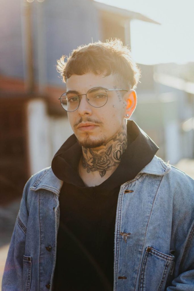 Man with texas jacket and glasses with a rose neck tattoo