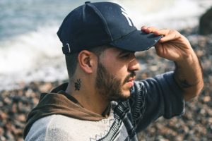 Man with baseball cap and a side neck tattoo