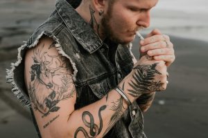 A man with a cigarette and Shoulder Tattoo