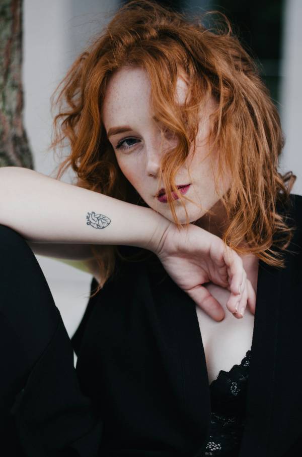 Woman leaning on a leg with a heart tattoo
