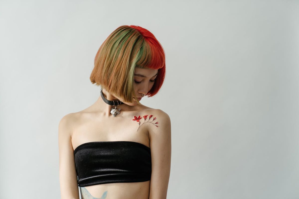 A woman with a short hair and flower tattoo on her shoulder